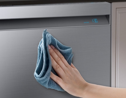 Hand using microfiber cloth to clean exterior of dishwasher