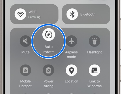 Close-up view of a Galaxy phone's quick settings panel highlighting the 'Auto rotate' feature within a circle, surrounded by other system settings like Wi-Fi and Bluetooth