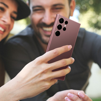 A smiling couple using a Galaxy phone to make a video call, highlighting its advanced calling features