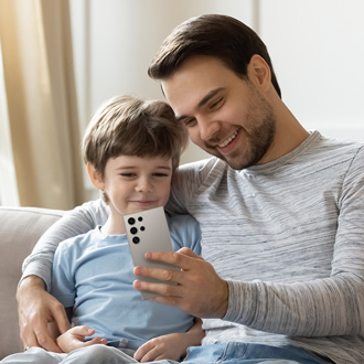 Father and son holding a Galaxy S24 Ultra