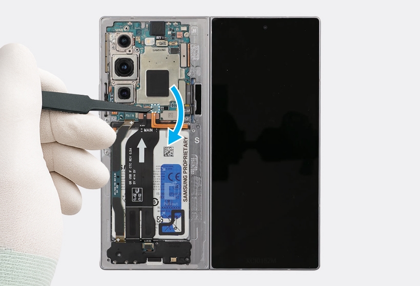 A gloved hand uses tweezers to disconnect a NFC connector from the main board of an opened Galaxy Z Fold6.
