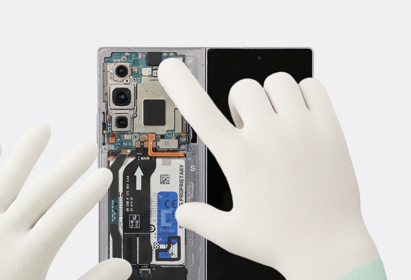 A gloved finger pressing down on the front camera connector to secure it to the main board of a Galaxy Z Fold6.