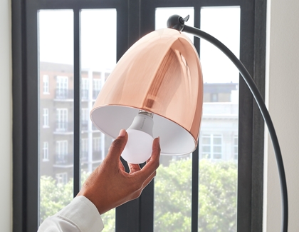Person inserting smart bulb into lamp