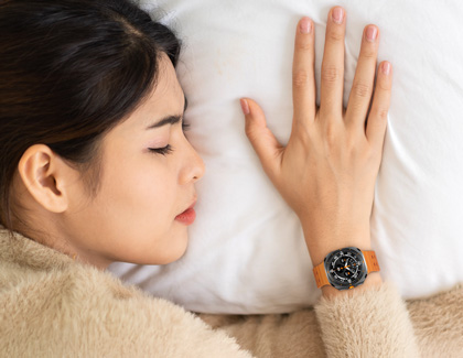 A woman sleeping while wearing a Samsung Galaxy Watch.