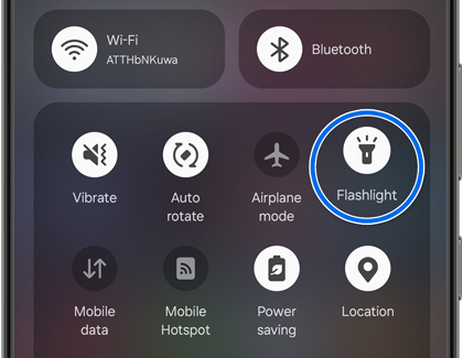 The Quick settings panel with the Flashlight icon highlighted