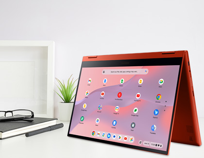 Samsung Galaxy Chromebook 2 in tablet mode on a desk with a notebook, pen, and glasses beside it