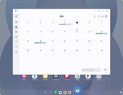 A Samsung DeX screen with a calendar window and the taskbar at the bottom showing a blue circle under the active calendar icon.