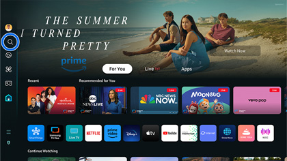 Smart Hub home screen on a Samsung monitor showing the app interface with a highlighted search icon on the left and streaming apps like Prime Video, Netflix, and YouTube.