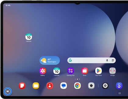 A Galaxy tablet showing a home screen in DeX mode with a blue circle highlighting the app drawer icon in the bottom left corner.