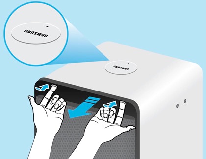 An illustration showing hands removing the top cover of a Samsung air purifier during unboxing.