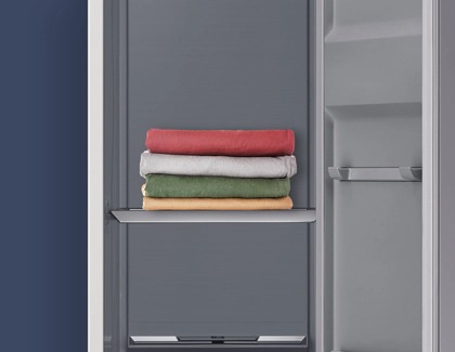 Samsung AirDresser with the door open, showing neatly folded clothes on the interior shelf.