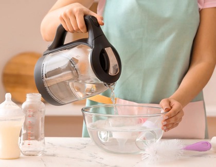 Woman pouring hot water in a container