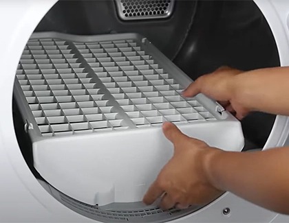 A person installing a drying rack inside a Samsung dryer.