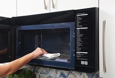 Person cleaning the inside of their microwave