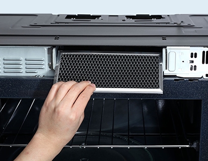 Person inserting the new charcoal filter in the Samsung microwave