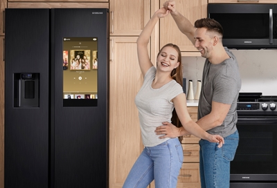 Couple dancing while playing Spotify on Family Hub
