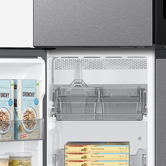 An open Samsung fridge showing organized shelves with boxes of pizza and the ice maker visible at the top.