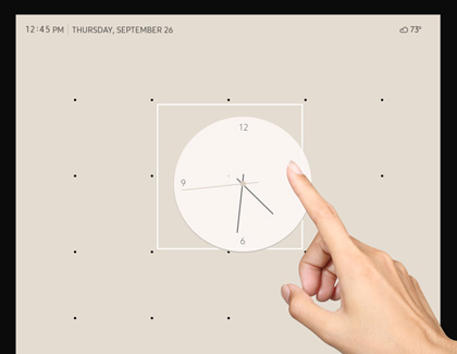A finger repositioning the clock widget on the home screen
