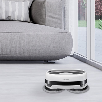 Samsung Jetbot mop cleaning the floor in a modern living room, with a sofa and large window in the background