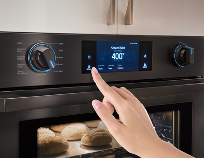Person setting clock automatically on the wall oven