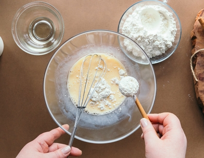 Using spoon to measure sugar to bake a cake