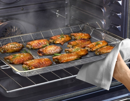 Taking out chicken wings from Samsung convection oven