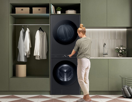 A women approaching the Samsung Bespoke washer and dryer in a laundry room at home.