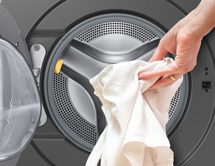 An image of a person opening a washing machine.