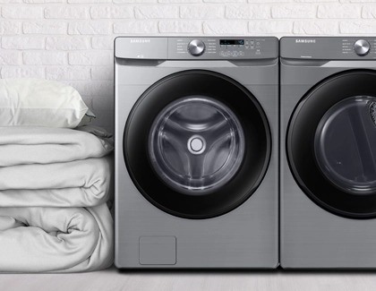 Comforters on the side of a Samsung washer and dryer