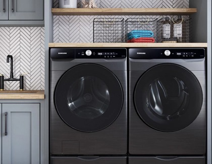 A Samsung front load washer and dryer set installed side by side in a laundry room