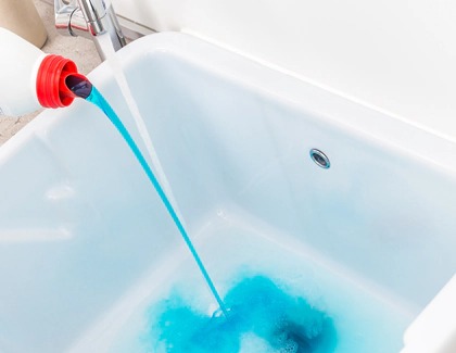 Woman pouring detergent into a sink