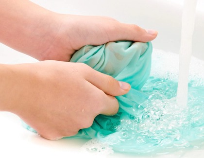 Woman swishing around curtains in clean water