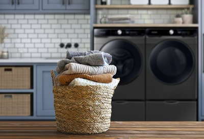 Winter fabrics in wicker basket with Samsung washing machine in the background