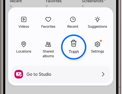 The Gallery app on a Samsung Galaxy phone with the Trash icon being highlighted with a blue circle.