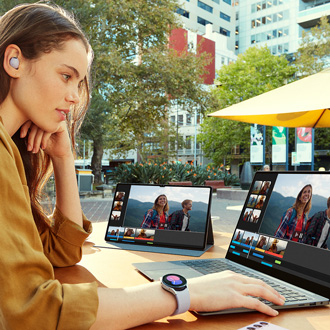 Woman using a Galaxy Book while duplicating the screen on a Galaxy tablet