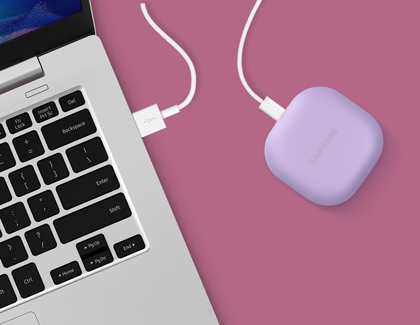 A Galaxy Buds2 Pro case that is charging next to a laptop
