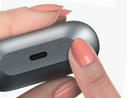 Hand holding a charging case with Galaxy Buds3 Pro, focusing on a thumb pressing the pairing button on the case