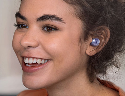 A woman smiling while wearing Galaxy Buds Pro