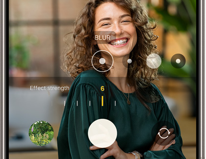 A smartphone screen showing a photo editing app with a portrait of a smiling woman. The blur effect is being adjusted using a slider.