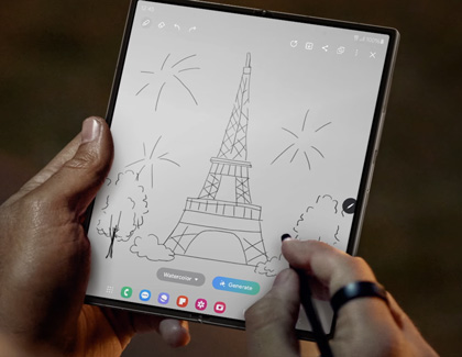 A person using an S Pen to draw an image of the Eiffel Tower on a Samsung Galaxy foldable device. The screen displays drawing tools and options at the bottom.