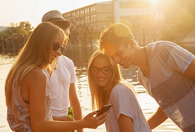 Friends looking at photos on phone outside