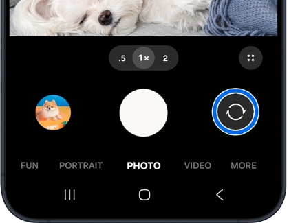 A camera interface on a Galaxy A series phone screen with the switch camera icon highlighted in a blue circle.