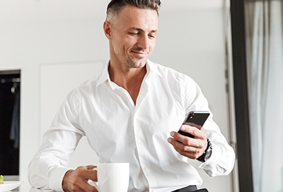 Man looking at his phone's IMEI or Serial number while drinking coffee