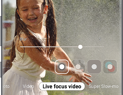 Phone showing video of girl playing with water on live focus video