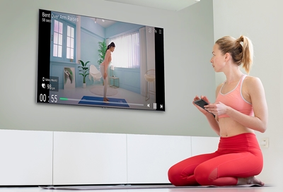 Female using S21 to mirror her workout routine on Samsung TV