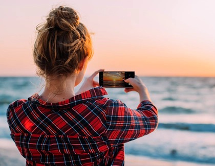 A Woman taking a photo of the sunset