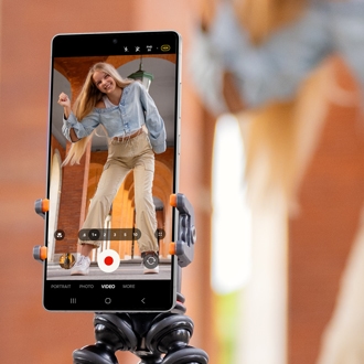 Galaxy phone screen displaying the Camera app in video recording mode. A woman is visible in the viewfinder, dancing energetically.