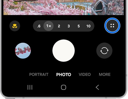 Galaxy S25 Ultra camera interface in Photo mode with zoom options and a cherry blossom preview.