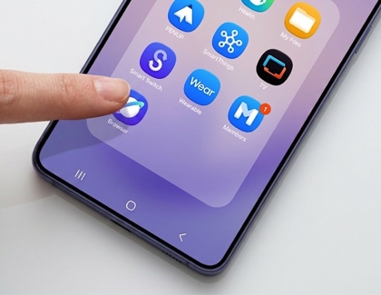 A person tapping the Samsung Browser icon on a purple Galaxy S26 phone home screen.
