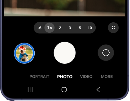 A Galaxy phone showing the Camera app in Photo mode with a filtered dog photo thumbnail highlighted in blue in the bottom left corner.
